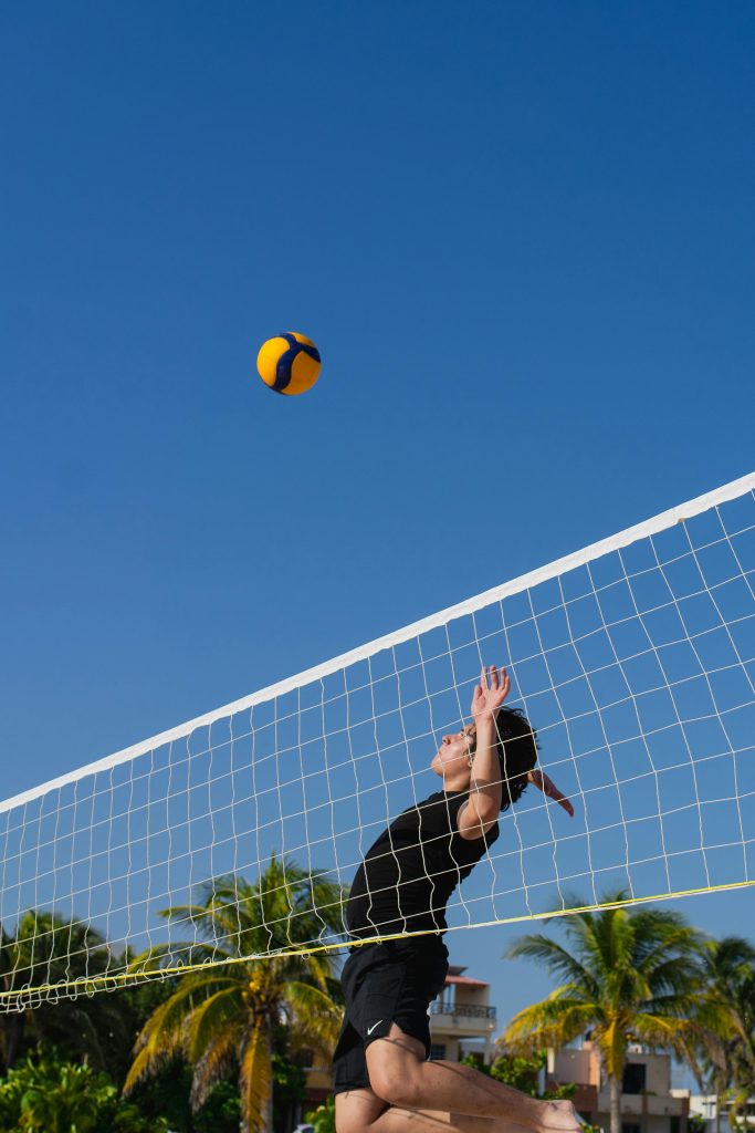 Beach volleyball action shot in Progreso, Yucatan, capturing summer sports fun under clear blue skies.